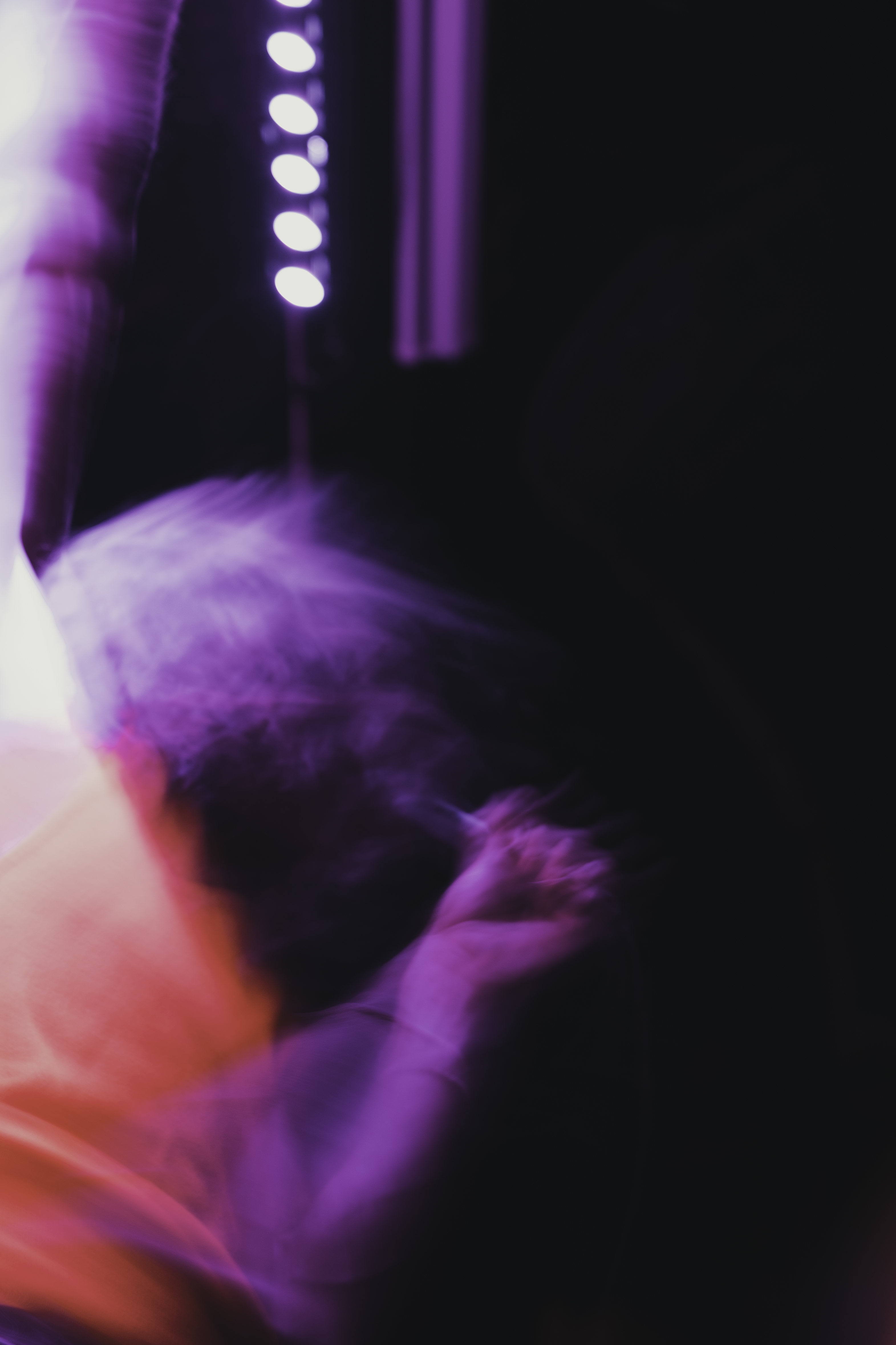 Motion-blurred dancer under purple stage lights
